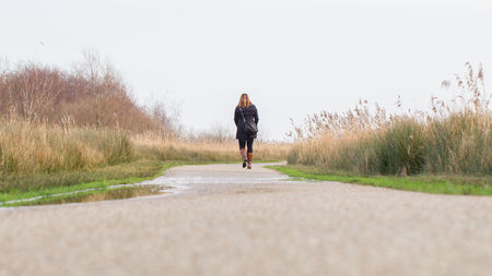 Young woman walking in a typical dutch landscapeの写真素材