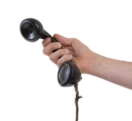 Male hand holding retro landline telephone, nearly broken cableの写真素材