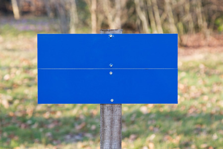 Blank blue road sign standing in a fieldの写真素材