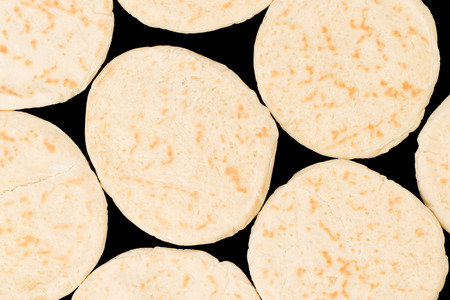 Israeli flat bread pita isolated on black backgroundの写真素材