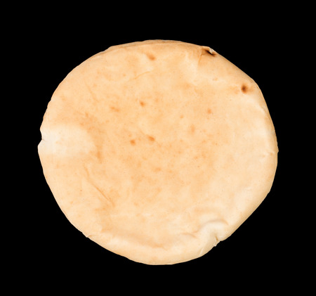 Single israeli flat bread pita isolated on black background