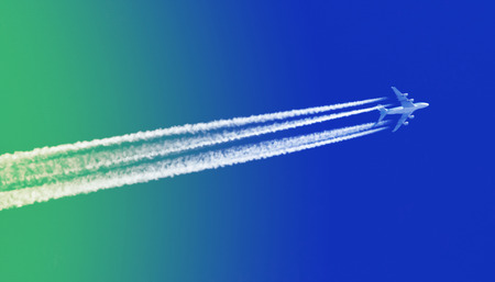 Large aircraft flying in sky, 4 stripes in the sky - Bright blue and green skyの写真素材