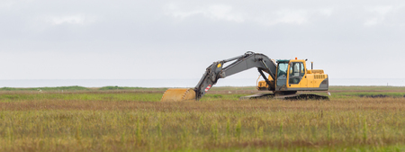 Yellow digger working in a field in Iceland