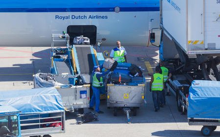 AMSTERDAM, NETHERLANDS - AUGUST 17, 2016: Loading luggage in airplane at Amsterdam Schiphol airport, Netherlands on August 17, 2016. Schiphol is the fourth biggest airport in Europe.のeditorial素材