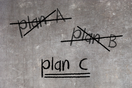 Crossing out Plan A and Plan B and writing Plan C, concept for change of planの写真素材