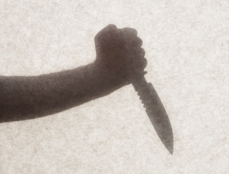 Silhouette behind a transparent paper - Knife threatの写真素材