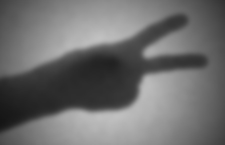 Silhouette behind a transparent paper - Blurred - Peace or victoryの写真素材