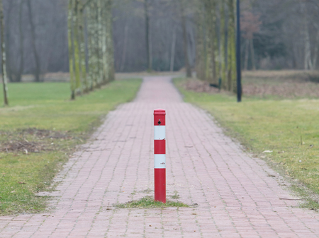 Close up, red and white traffic pole in the middle of the roadの写真素材