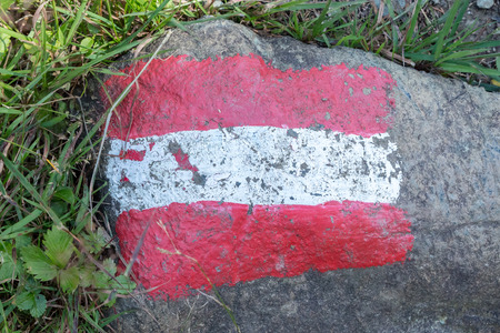 Walking path sign in Austria, flag painted on a rockの写真素材