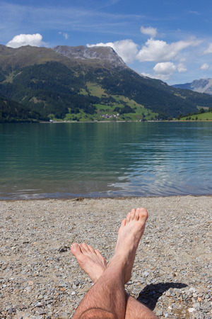 Feet on the beach, relaxing at the Reschensee - Italyの写真素材