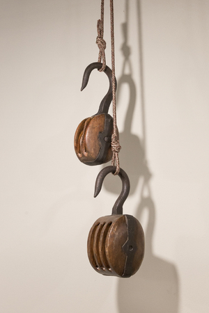 Old wooden pulley, isolated on a white wall