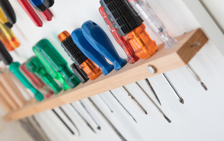 Assorted tools on a white tool board - Selective focusの写真素材