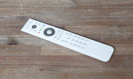 Single white remote on a wooden table