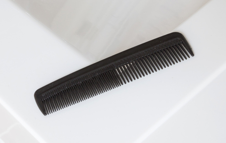 Used black comb in a bathroom - Selective focusの写真素材