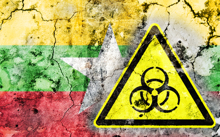 Old cracked wall with biohazard warning sign and painted flag, flag of Myanmarの写真素材