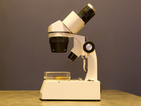 Old simple microscope isolated on a table