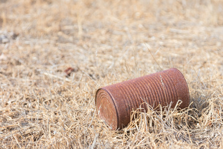Garbage in nature - A rusty can on a fieldの写真素材