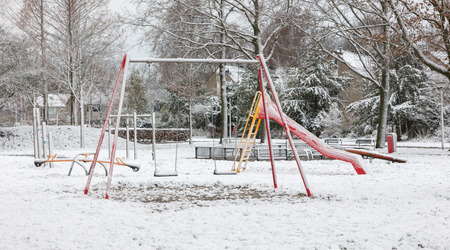 Empty swing in playground - Covered in snowの写真素材