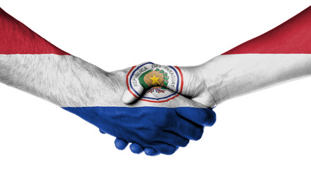 Man and woman shaking hands, wrapped in flag pattern, Paraguayの写真素材