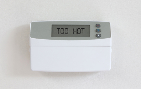 Vintage digital thermostat hanging on a white wall - Covert in dust - Too hotの写真素材