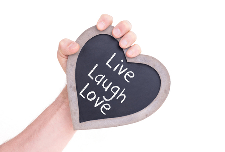 Adult holding heart shaped chalkboard - Isolated on white - Live laugh loveの写真素材