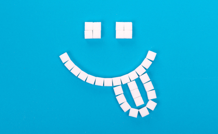 White sugar background, smiley - Concept of unhealthy eatingの写真素材