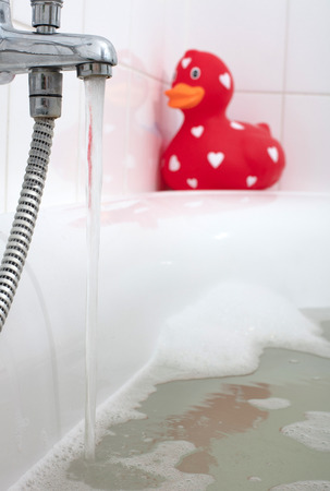 Large red rubber duck in a bathtub, selective focusの写真素材