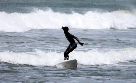 Surfer surfing the waces in the Gambiaの写真素材