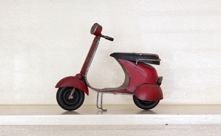 Retro scooter isolated, standing on a wooden shelfの写真素材