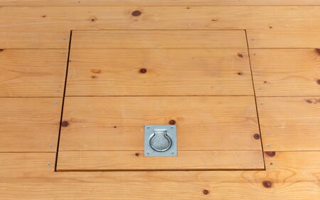 Wooden square old hatchway in the cellar in the floor of wooden planks