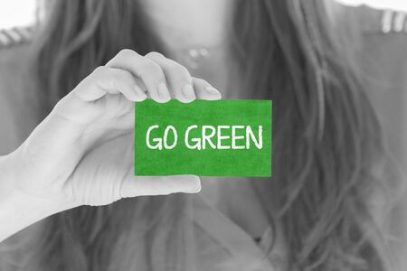 Woman showing a small message: Go Green
