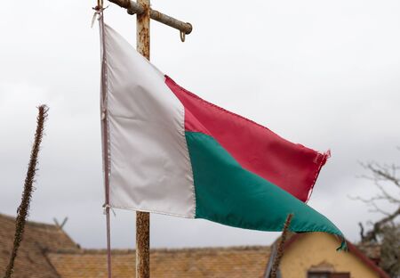 Flag of Madagascar waving in a Malagasy villageの写真素材