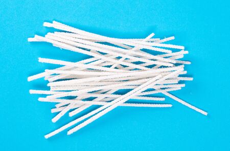 Small white pipe cleaners, isolated on blue