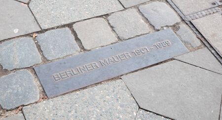 Two rows of stones and this label on the streets of Berlin mark where the wall between east and west berlin used to beのeditorial素材