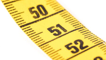 Close-up of a yellow measuring tape isolated on white - 51 - Selective focus