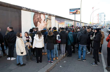 Berlin, Germany on Januari 1, 2020: Tourists in front of a kissing Leonid Brezhnev and Erich...