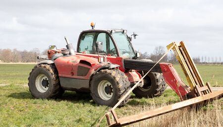 Rural farm tractor fork lift at the side of the road
