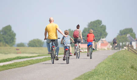 Cyclists cycling on a dyke, Friesland, the Netherlands