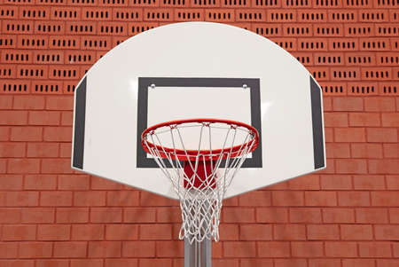Basket in a school gym, red brick wall