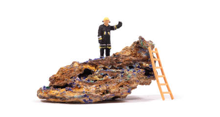 Malachite - Azurite mineral stone with a small fireman on it, isolated on whiteの写真素材