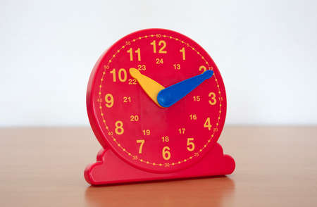 Red clock in a primary school - Learning children how to tell the time on clock
