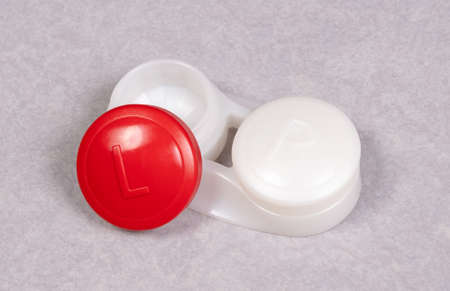 Red contact lens case, isolated on gray background