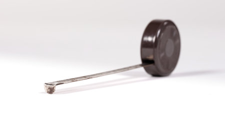 Old scratched brown metal tape measure, measuring on whiteの写真素材