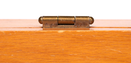Small door hinge of gold color on a wooden box, selective focusの写真素材