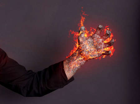 Hand magically burning, black background - Concept of powerの写真素材
