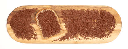 Typical dutch chocolate sprinkles on a slice of bread, served on a wooden plate, isolated