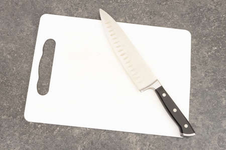 Plastic cutting board and knife isolated on white background