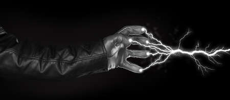 Hand shooting out a bolt of lightning - Dark and mysterious, isolated on blackの写真素材
