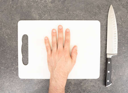 Cutting the fingers with knife - Preparation - Isolated on whiteの写真素材