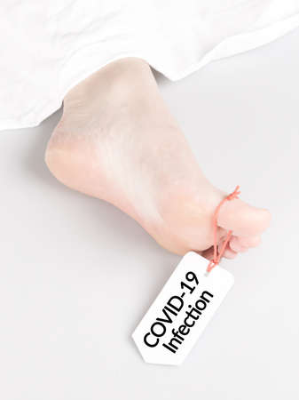 Body with toe tag on white, under a white sheet - Covid-19 infection